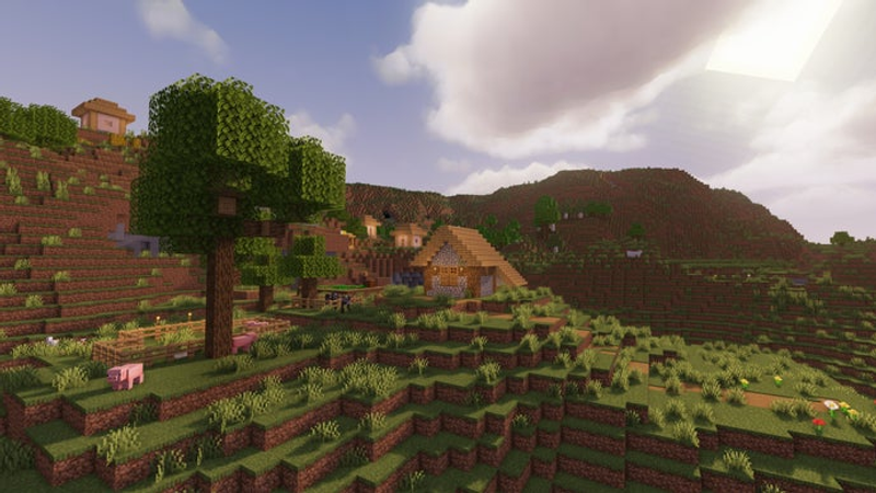 Uma paisagem de colinas extremas no servidor Minecraft, com uma árvore em primeiro plano e uma vila ao fundo.
